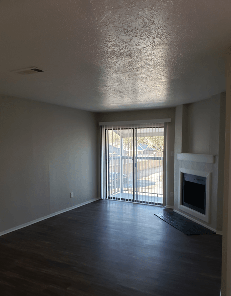 A room with a fireplace and sliding glass doors.
